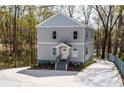 A well-designed house with a multilevel deck and a large driveway, nestled in a tree-lined area at 2125 Clay Rd, Austell, GA 30106