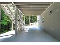 Covered patio featuring modern design, staircase access, and outdoor living space for relaxation and entertaining at 2125 Clay Rd, Austell, GA 30106