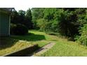 Green backyard featuring lush greenery and partial views of the house's siding at 330 Christian Woods Dr, Conyers, GA 30013
