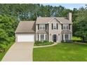 Charming two-story home features a manicured lawn, attached garage, and classic architectural details at 405 Mount Vernon Ct, Woodstock, GA 30189