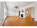 Spacious living room featuring hardwood floors, a fireplace, and arched doorways at 6043 China Rose Lane, Johns Creek, GA 30097