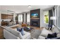 Open-concept living room with a fireplace, hardwood floors, comfortable seating, and a view into the dining area at 1063 Winding Branch Dr, Canton, GA 30114
