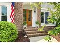 Elegant front door entrance with a brick facade, sidelights, and a well-maintained landscape at 113 Stargaze Rdg, Canton, GA 30114