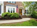 Inviting front entrance with a charming brick walkway, a wood door, and manicured bushes at 113 Stargaze Rdg, Canton, GA 30114