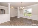 Bright dining room with hardwood floors, wainscoting, large window, and elegant chandelier at 251 Eason St, Bowdon, GA 30108