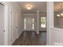 Welcoming foyer with hardwood floors, transom window, and decorative columns, offering a seamless transition at 251 Eason St, Bowdon, GA 30108