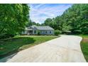Spacious concrete driveway leading up to a well-maintained house surrounded by mature trees at 1460 Bakers Bridge Rd, Douglasville, GA 30134