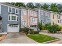 Row of charming townhomes featuring colorful facades, driveways, and beautiful landscaping at 3745 Meeting St, Duluth, GA 30096