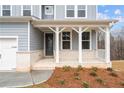 Inviting covered front porch with brick accents, white columns, and a stylish entrance at 109 Laurelwood Ln, Dallas, GA 30157