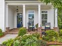 Inviting front porch features brick accents, rocking chairs, and lush landscaping at 309 Mcdaniel Pl, Canton, GA 30115