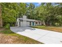 A single-story house with a white brick exterior, accented by a long driveway leading to the property at 4345 Sasanqua Ct, Tucker, GA 30084