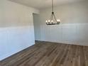 Dining room with wainscotting and a black chandelier overlooking the hardwood floors at 57 Longhorn Way, Auburn, GA 30011