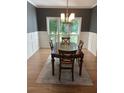 Traditional dining room showcasing a dark wood table, decorative wainscoting and a large window at 5920 Findley Chase Dr, Johns Creek, GA 30097