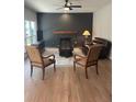 Cozy living room featuring a brick fireplace, dark accent wall and plush leather sofa at 5920 Findley Chase Dr, Johns Creek, GA 30097