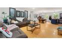 Open-concept living room featuring wood floors and a large cozy sofa at 165 Wellington Dr, Mcdonough, GA 30252