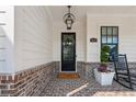 Charming porch with black rocking chair, brick accents, and beautiful door at 4020 Connolly Ct, Roswell, GA 30075