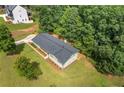 Aerial view of a well-maintained home with a new roof, set on a spacious lot surrounded by lush greenery at 6142 Hutchins Dr, Buford, GA 30518