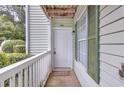 Inviting entryway with covered porch, light green siding, and white door at 301 Cobblestone Trl, Avondale Estates, GA 30002