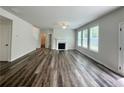 Bright living room featuring wood flooring, a fireplace, and lots of natural light from multiple windows at 365 Rodeo Dr, Auburn, GA 30011