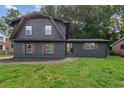 Two-story home with dark brick exterior, wooden shutters, and beautifully maintained landscaping at 1239 Teakwood Trl, Stone Mountain, GA 30083