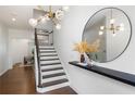 Bright foyer featuring hardwood floors, a staircase, and an elegant light fixture at 203 Holden Way, Woodstock, GA 30189