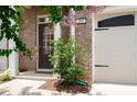 Inviting entrance with decorative plants, a partial garage door, and a well-maintained walkway at 203 Holden Way, Woodstock, GA 30189
