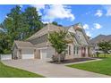 A beautiful two-story home showcasing a three-car garage and a well-maintained lawn and landscaped grounds at 2118 Harmony Dr, Canton, GA 30115