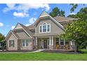 Charming two-story home featuring a brick and shingle facade with a covered porch and well-manicured lawn at 2118 Harmony Dr, Canton, GA 30115
