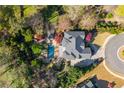 An aerial shot showcases the backyard pool, patio, lush landscaping, and driveway of the property at 2461 Oak Grove Ne Ests, Atlanta, GA 30345