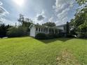 Spacious yard surrounding a light grey home with charming features at 1610 Sprayberry Dr, Marietta, GA 30066