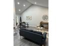 Bright living room featuring vaulted ceilings, dining table, decor, and sleek gray flooring at 539 Rue Montaigne, Stone Mountain, GA 30083