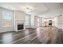 Open-concept living room featuring a fireplace, hardwood floors, and an adjacent kitchen with stainless appliances at 606 Rodeo Dr, Auburn, GA 30011