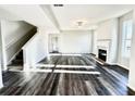 Spacious living room with a fireplace, hardwood floors, and a staircase leading to the upper level at 606 Rodeo Dr, Auburn, GA 30011