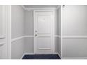 Apartment 714's front door; neutral walls, trim, and blue carpet at 2965 Pharr Nw Ct # 714, Atlanta, GA 30305