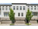 Townhomes showcase white brick, garages, manicured trees, and gray trim at 215 Arizona Ne Ave # 3, Atlanta, GA 30307