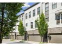 Modern townhomes with white brick, gray trim, garages, and manicured trees at 215 Arizona Ne Ave # 3, Atlanta, GA 30307