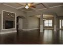 Open-concept living room with a fireplace, coffered ceilings, and hardwood floors at 505 Mirror Lake Pkwy, Villa Rica, GA 30180