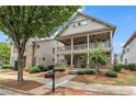 Welcoming two-story home showcasing a charming front porch and a balcony, surrounded by a beautifully landscaped garden at 559 Myrle Trace Ln, Suwanee, GA 30024