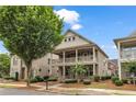 Charming two-story home with a inviting front porch and a balcony, complemented by professionally landscaped greenery at 559 Myrle Trace Ln, Suwanee, GA 30024