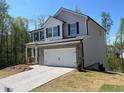 Two-story home featuring a two-car garage, gray siding, brick accents, and a well-manicured lawn at 108 Deer Xing, Temple, GA 30179
