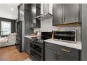 Stylish kitchen boasts dark gray cabinets, stainless steel oven and microwave, and modern countertops at 988 Viney Nw Way, Atlanta, GA 30318