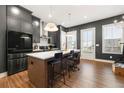 Modern kitchen features gray cabinetry, a stainless steel refrigerator, and a white countertop island with barstool seating at 988 Viney Nw Way, Atlanta, GA 30318