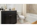 Bathroom with a sleek, dark vanity, granite countertop and a shower featuring gold accents at 2673 Caruso Way, Atlanta, GA 30339