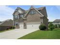 Attractive two-story brick home with a two-car garage and a well-maintained lawn at 4154 Hawking Dr, Suwanee, GA 30024