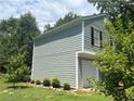 Side view of the house with a white garage door, siding, and well-maintained landscaping at 4164 River Shoals Ct, Duluth, GA 30097