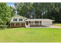 Charming two-story home with brick accents, white siding, and a welcoming covered front porch at 6000 Malibu Drive Dr, Morrow, GA 30260