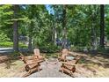 Outdoor stone firepit with Adirondack chairs on a stone patio surrounded by a lush, wooded landscape at 2316 Defoors Ferry Nw Rd, Atlanta, GA 30318