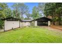 Charming ranch-style home with a well-manicured lawn, white brick, a black roof, and a two-car garage at 3068 Cherry Blossom Ln, Atlanta, GA 30344