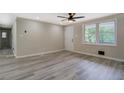 Spacious living room features a large window, a ceiling fan, and modern gray flooring at 4176 King Edward Dr, Douglasville, GA 30135