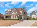 Elegant home featuring brick accents, well-maintained lawn, and a long driveway leading to a side-entry garage at 5810 Old Mill Trce, Lithonia, GA 30038